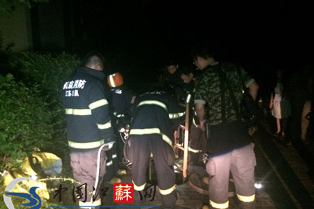 消防官兵正在對跌落窯井后的物業人員進行救援